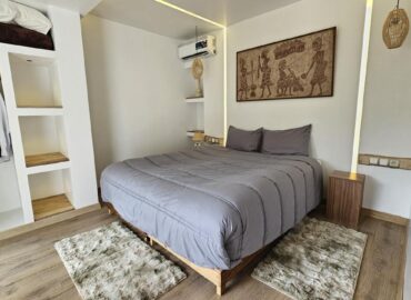 Luxury Studio bedroom with modern grey bedding and open wardrobe at Dar l'Eau Vive guest house