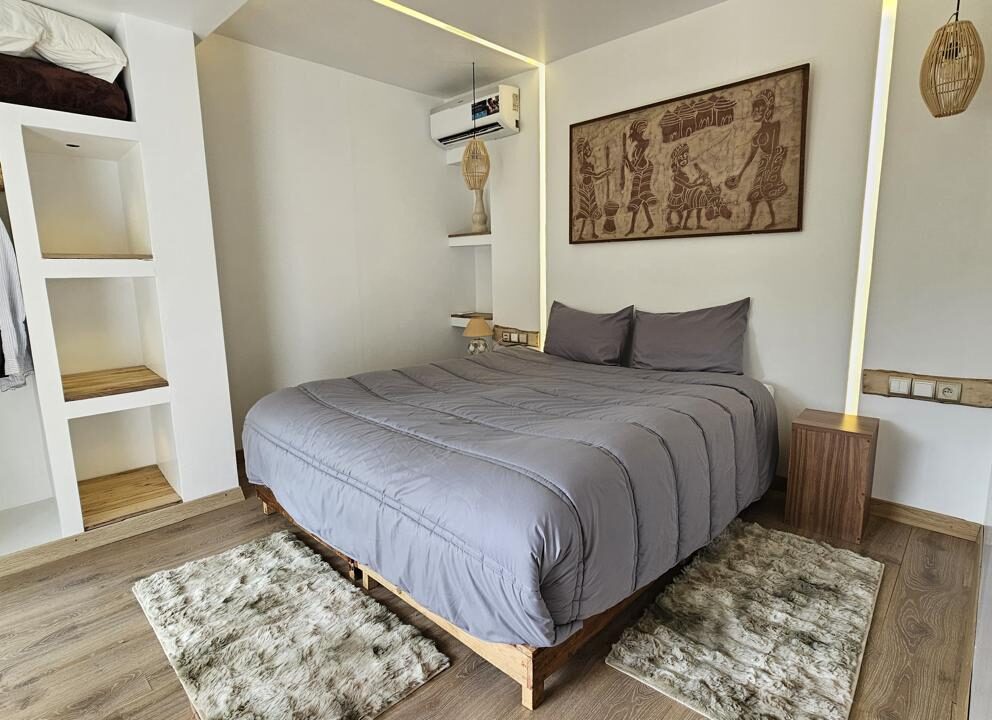 Luxury Studio bedroom with modern grey bedding and open wardrobe at Dar l'Eau Vive guest house